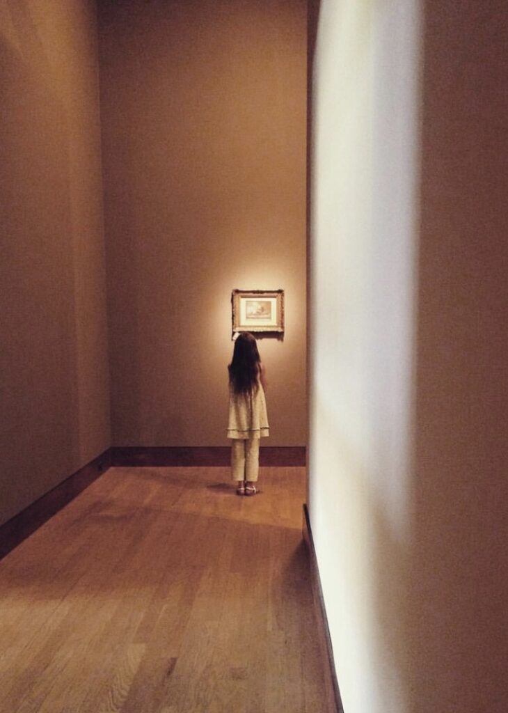 Young girl looking at artwork in museum